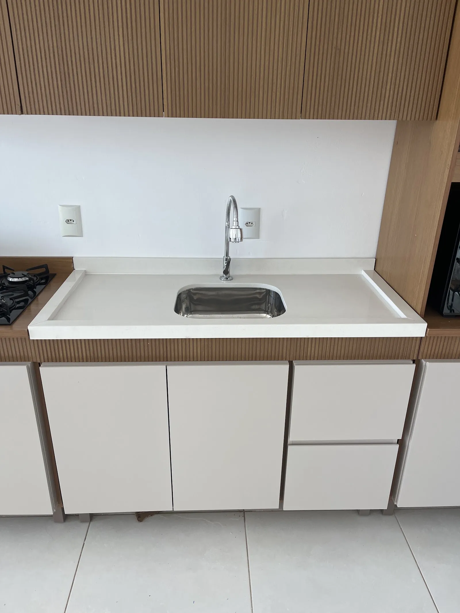 Bancada branca de cozinha com cuba de inox embutida